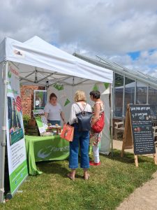 Two people stood talking to a member of staff at FareShare North East's stall 